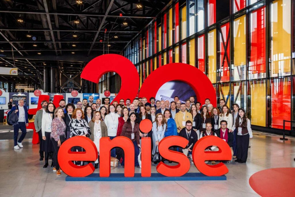 Fotografía de grupo de participantes en 20ENISE 2026 junto al logotipo del evento en León.